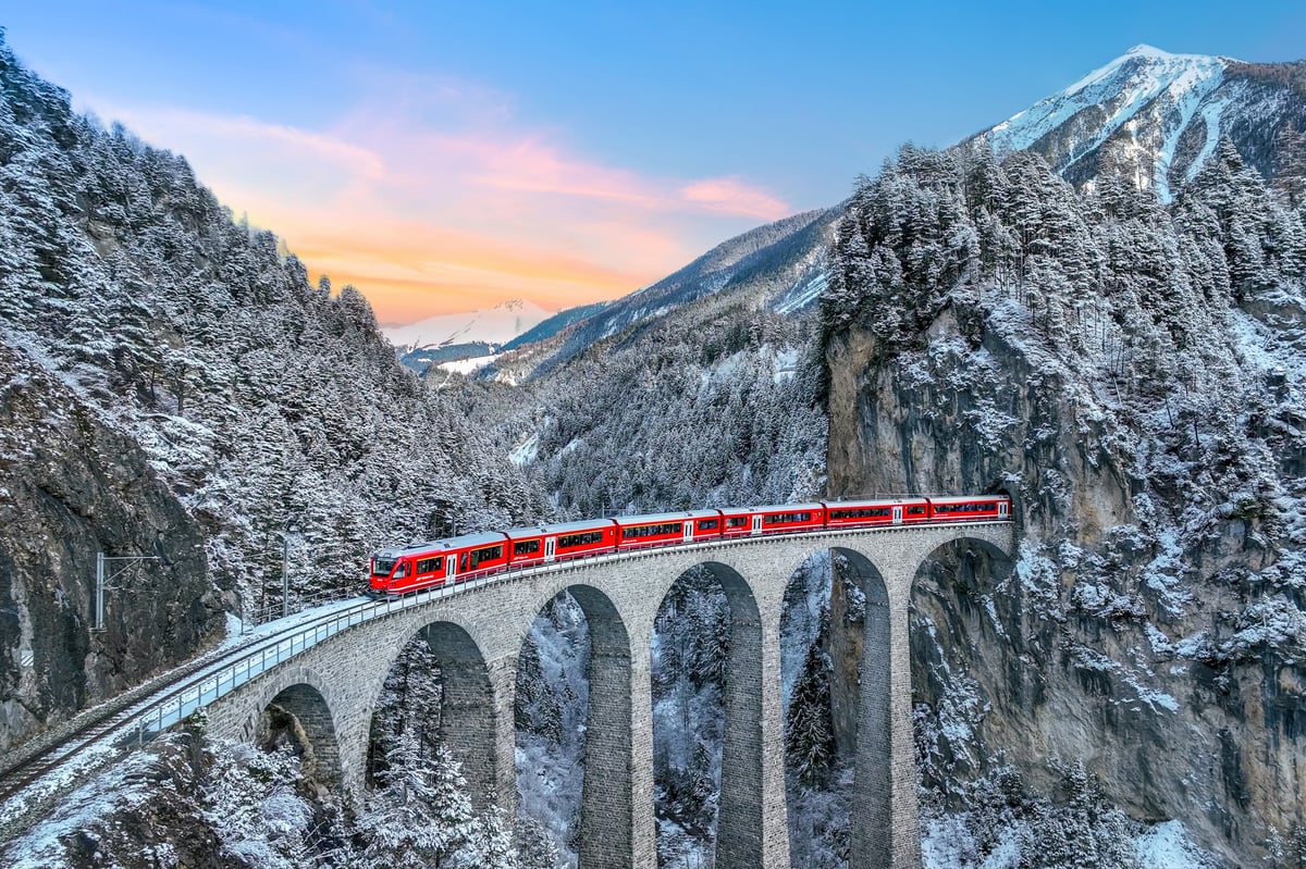 A bridge winding through a dramatic mountain landscape