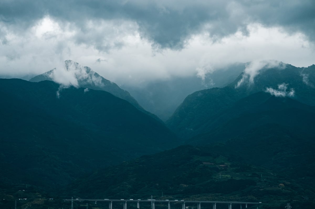 A bridge crossing a dramatic misty mountain valley